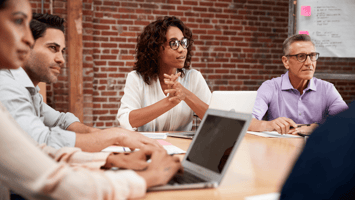 Employees listening to a speaker discuss the benefits of RSUs