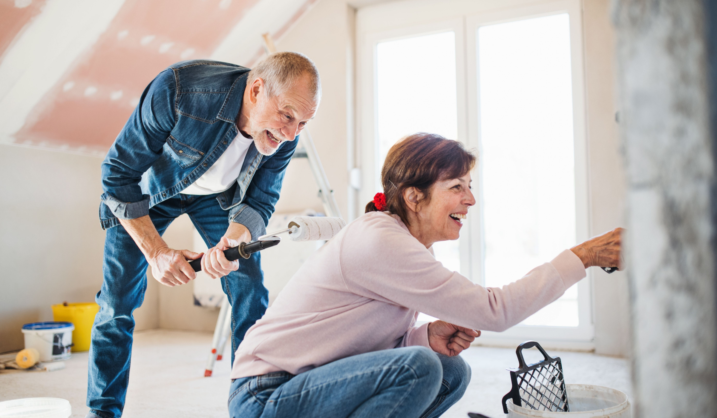 A couple having fun painting a room in their home